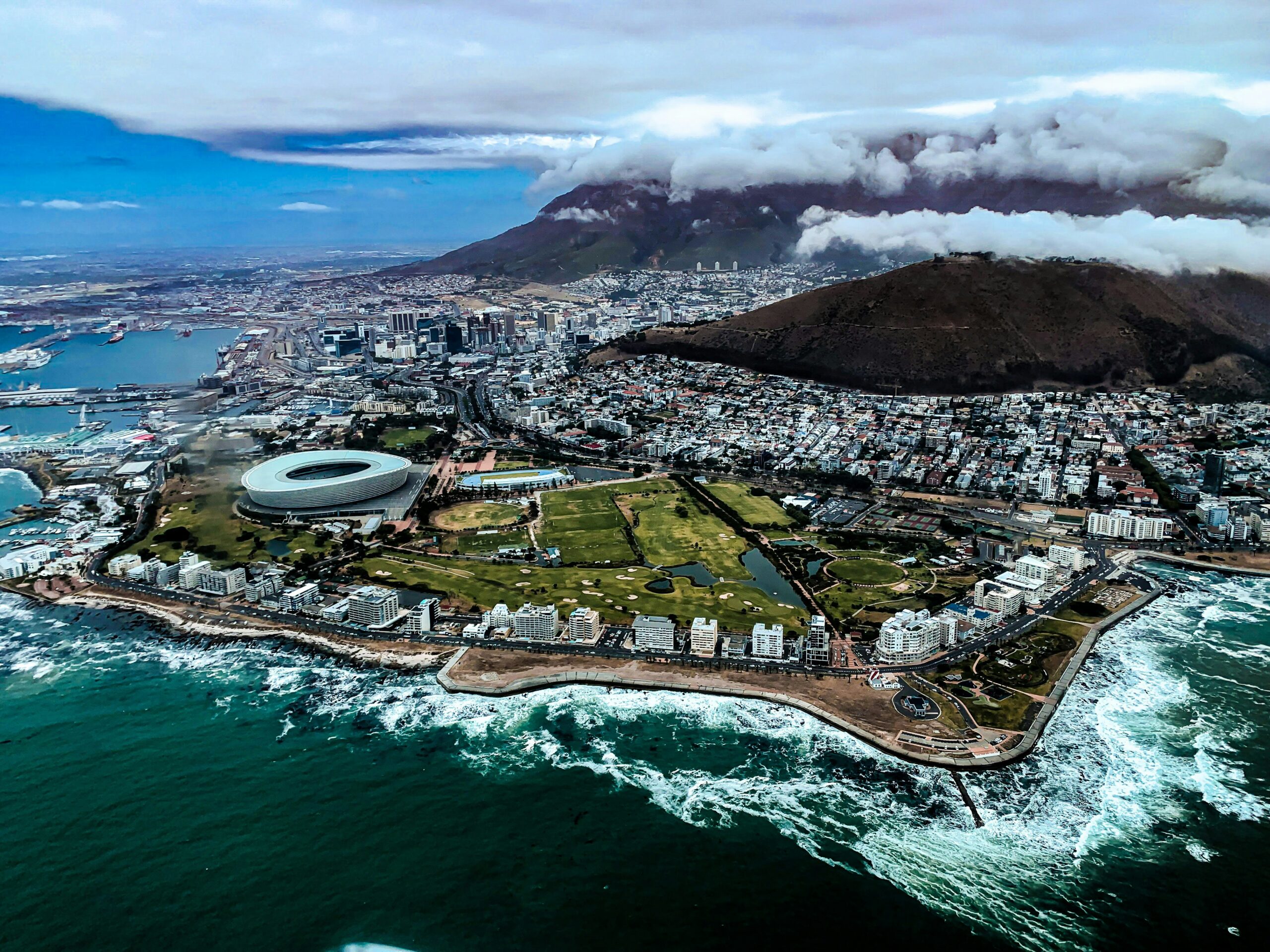 "A stunning view of Cape Town, South Africa, with Table Mountain towering over the city and the Atlantic Ocean stretching into the horizon."