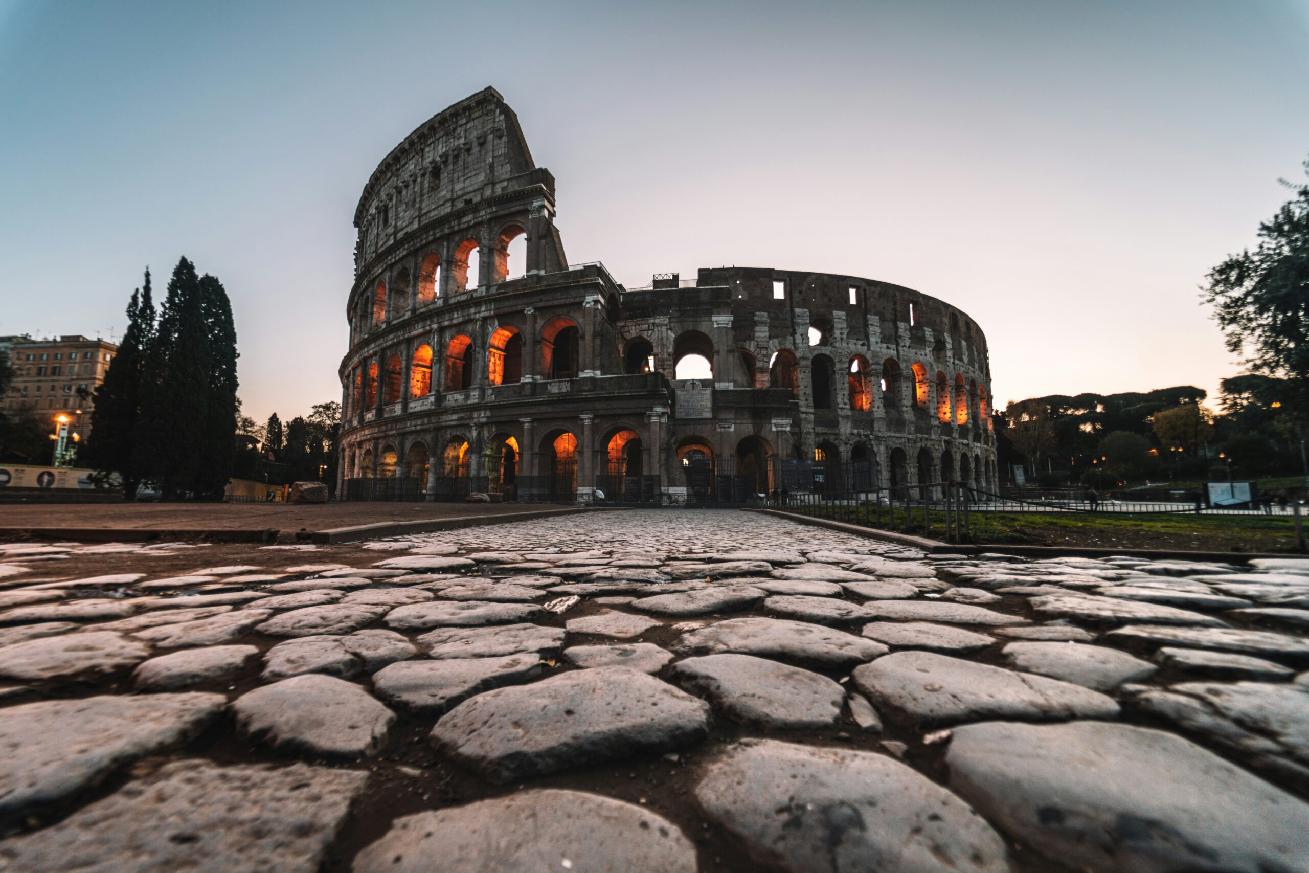 ✔ **"A stunning view of Rome, Italy, featuring the Colosseum, ancient ruins, and vibrant city streets under a golden sunset sky."**